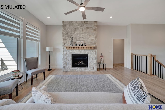 living room featuring light hardwood / wood-style floors, plenty of natural light, ceiling fan, and a fireplace