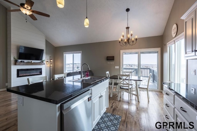 kitchen featuring sink, white cabinetry, dishwasher, and vaulted ceiling