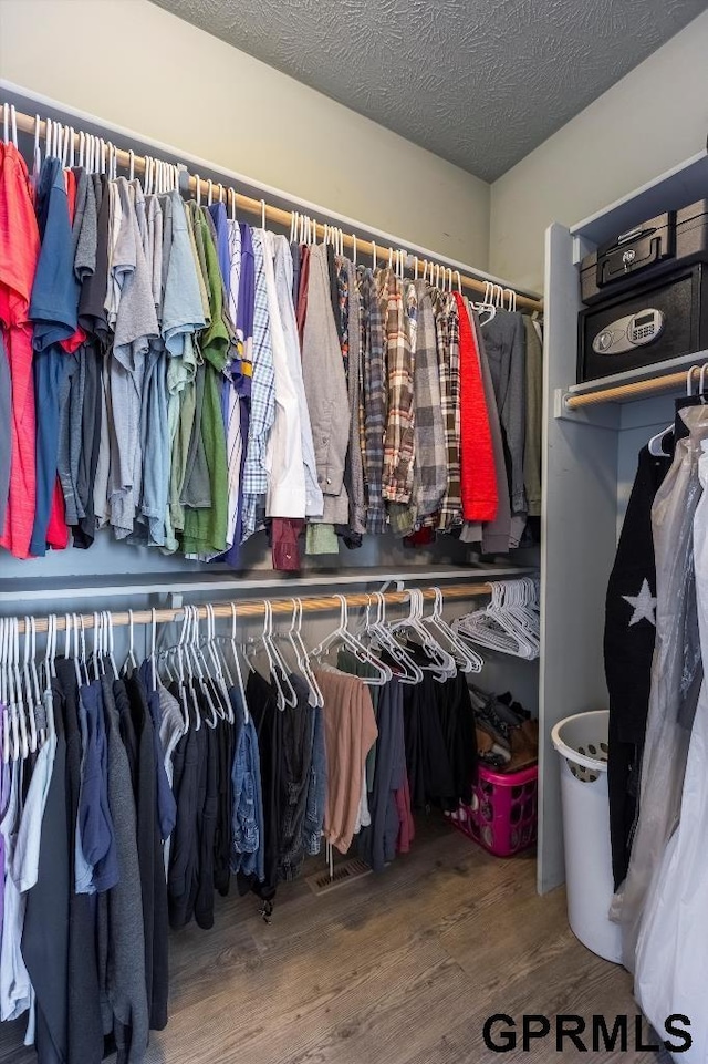 walk in closet with hardwood / wood-style floors