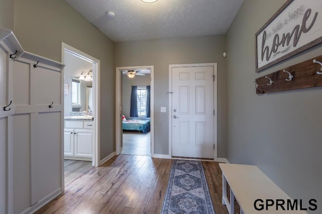 foyer with ceiling fan, light wood-type flooring, sink, and a textured ceiling