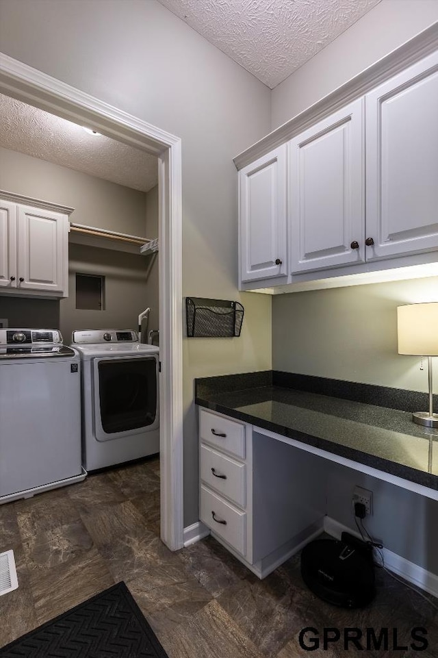 clothes washing area featuring washing machine and dryer, cabinets, and a textured ceiling