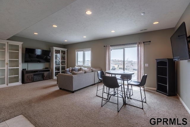 carpeted dining area featuring a textured ceiling