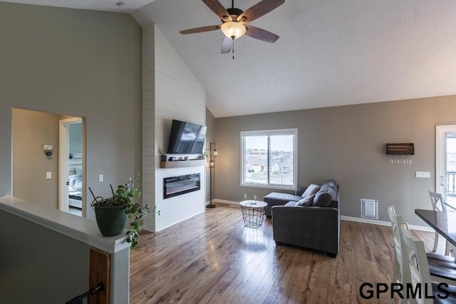 living room featuring ceiling fan, high vaulted ceiling, a fireplace, and hardwood / wood-style floors