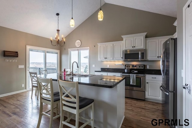 kitchen featuring stainless steel appliances, pendant lighting, white cabinetry, and sink