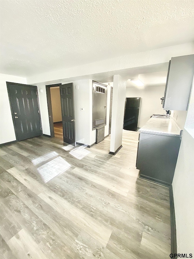 interior space with light wood-type flooring and a textured ceiling