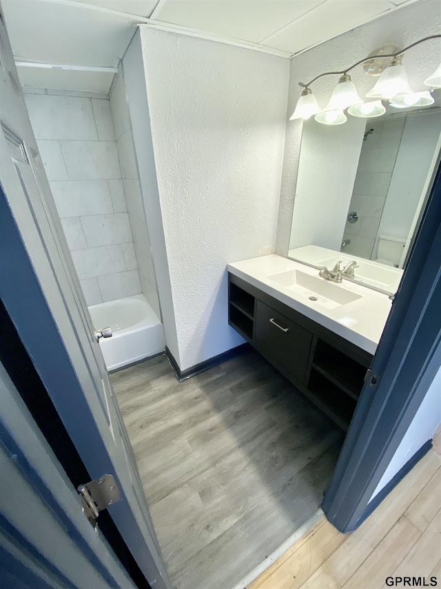 bathroom featuring tiled shower / bath, hardwood / wood-style flooring, and vanity