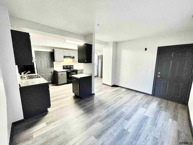 kitchen with light wood-type flooring, a textured ceiling, electric range, and sink