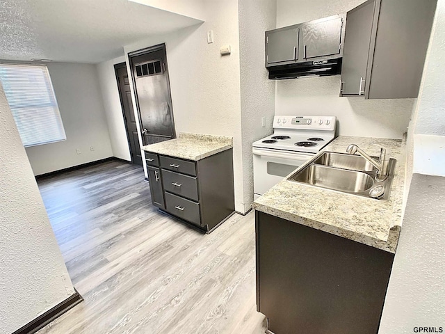 kitchen with electric range, sink, a textured ceiling, and light hardwood / wood-style floors