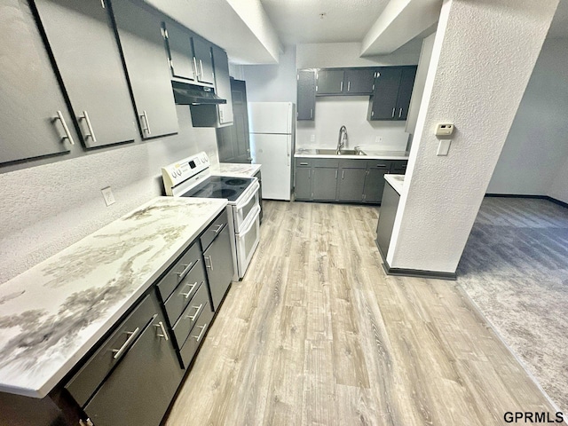 kitchen featuring light wood-type flooring, sink, and white appliances