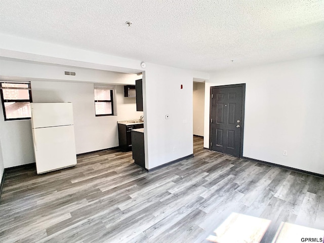 interior space with a textured ceiling and light hardwood / wood-style flooring