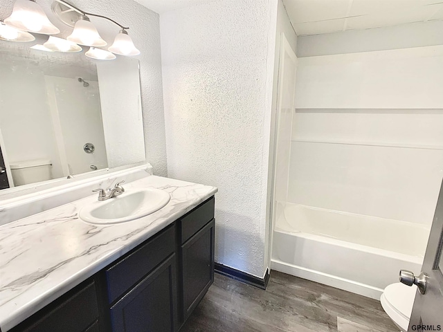 full bathroom with toilet, vanity, wood-type flooring, and shower / washtub combination