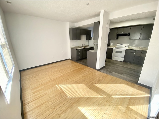 kitchen featuring extractor fan, white electric range oven, dark wood-type flooring, a textured ceiling, and sink