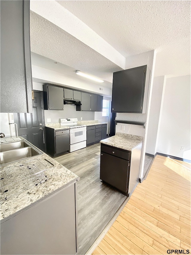 kitchen featuring light wood-type flooring, a textured ceiling, sink, and electric stove