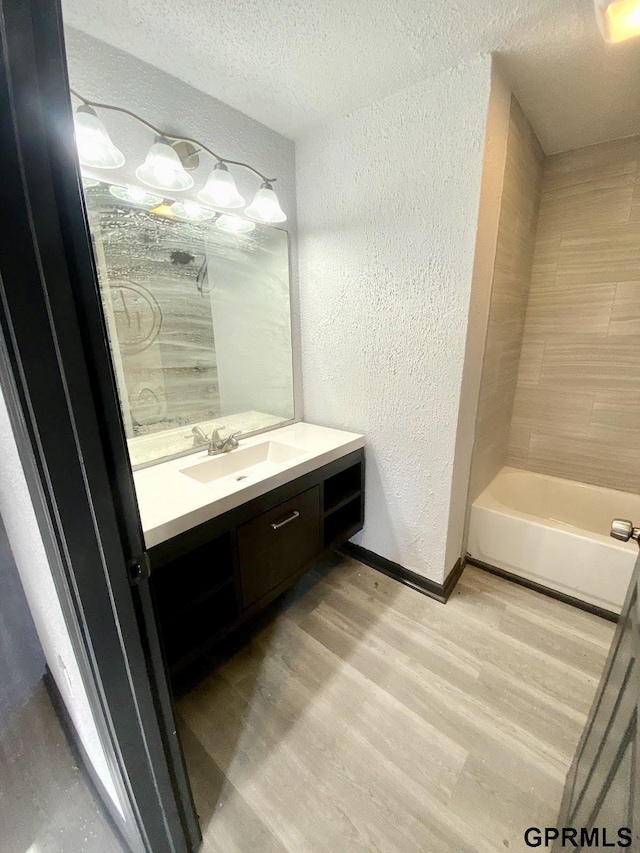 bathroom featuring a textured ceiling, wood-type flooring, and vanity