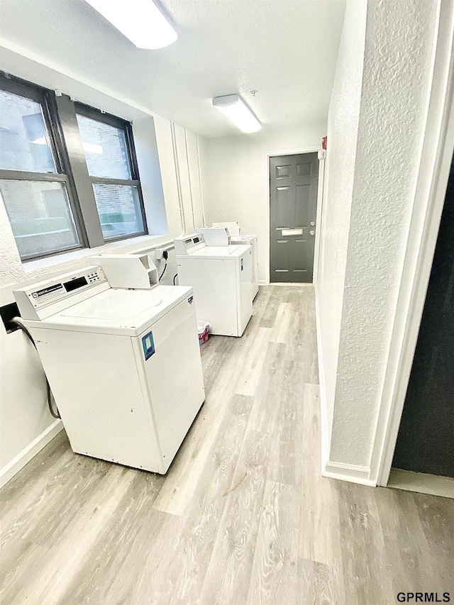 laundry room with light hardwood / wood-style floors and independent washer and dryer