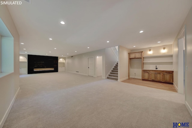 interior space featuring built in shelves and light colored carpet