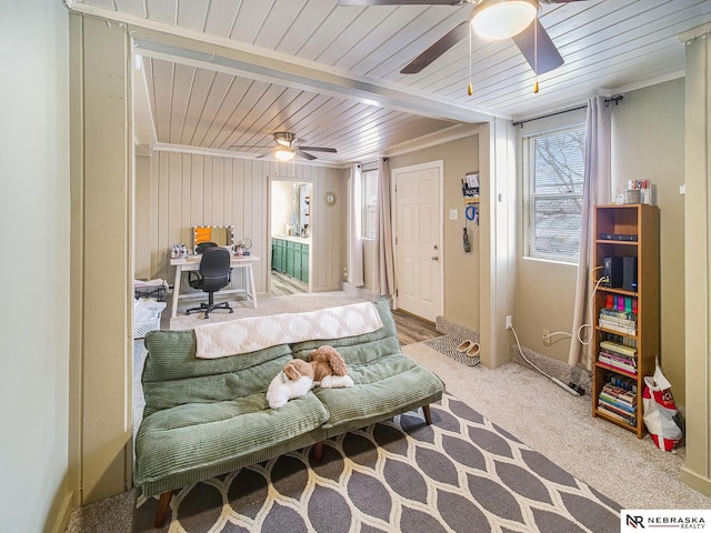 interior space featuring crown molding, wood ceiling, carpet flooring, wooden walls, and ceiling fan