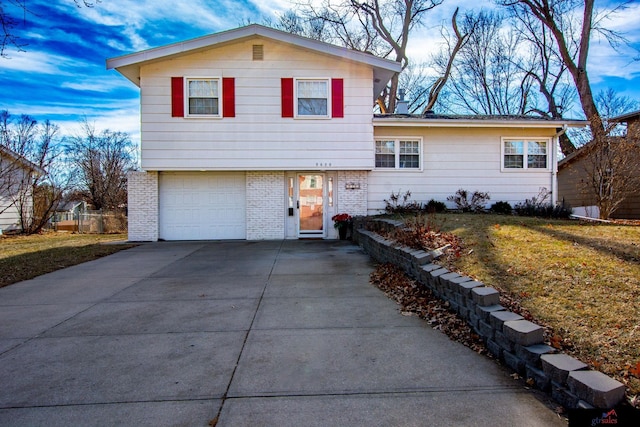 split level home with a front yard and a garage