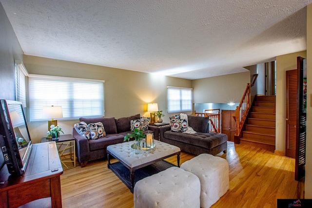 living room with light wood-type flooring and a textured ceiling