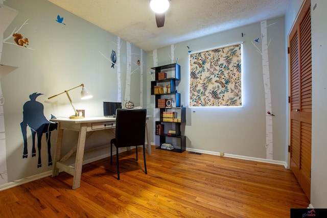 office space featuring hardwood / wood-style flooring, a textured ceiling, and ceiling fan