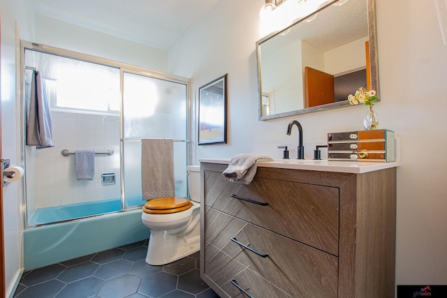 full bathroom featuring toilet, tile patterned flooring, vanity, and shower / bath combination with glass door