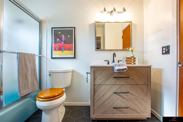 full bathroom featuring toilet, tile patterned floors, vanity, and enclosed tub / shower combo