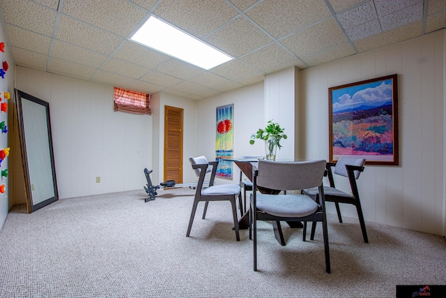 dining space with a drop ceiling and carpet flooring