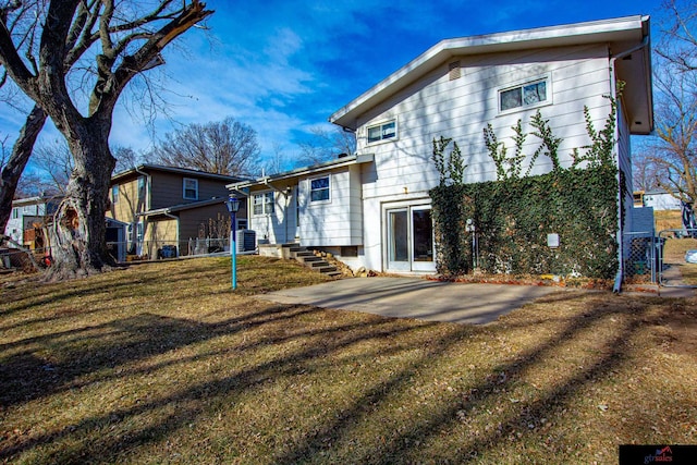 back of house featuring a lawn, central AC, and a patio