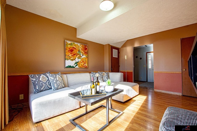 living room featuring a textured ceiling and light hardwood / wood-style flooring