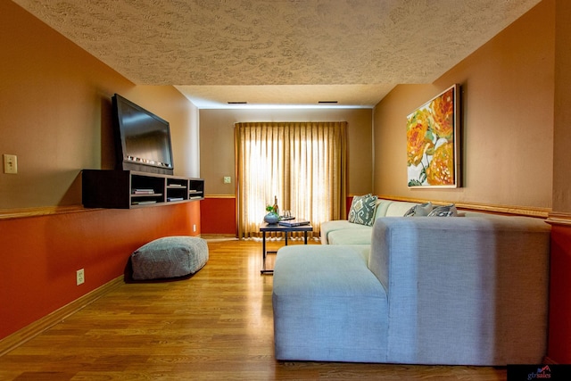 living room with wood-type flooring and a textured ceiling