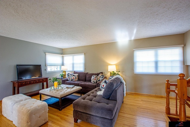 living room with a textured ceiling and light hardwood / wood-style flooring