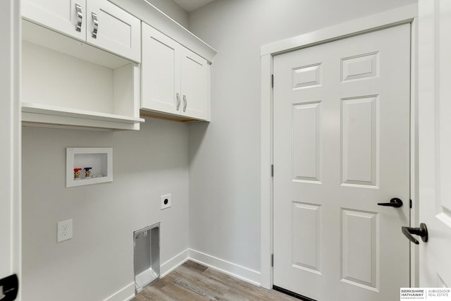 washroom featuring light wood-type flooring, hookup for an electric dryer, hookup for a washing machine, and cabinets