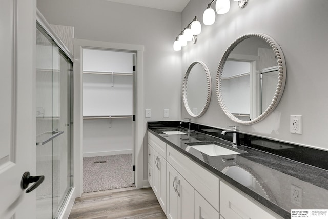 bathroom with vanity, a shower with door, and hardwood / wood-style floors