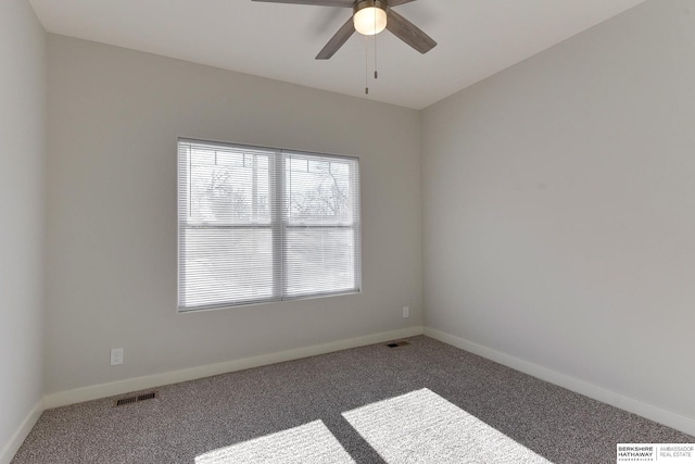 empty room featuring ceiling fan and carpet