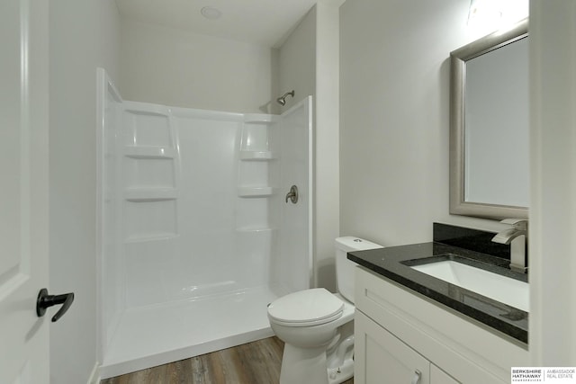 bathroom featuring toilet, vanity, walk in shower, and hardwood / wood-style floors