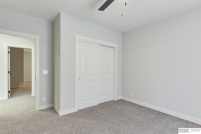 unfurnished bedroom with ceiling fan, a closet, and light carpet