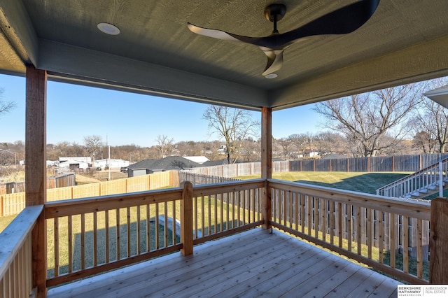 wooden terrace with ceiling fan and a lawn