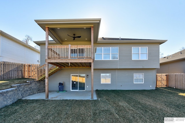 rear view of property featuring ceiling fan, a yard, and a patio