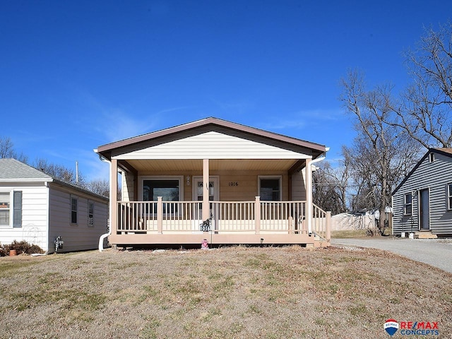 view of front facade featuring covered porch and a front lawn