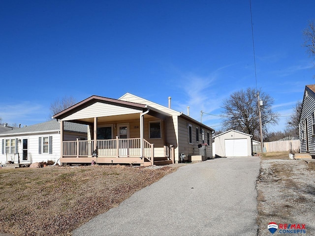 view of front of house with an outdoor structure, a porch, and a garage