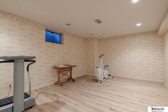 exercise room with light hardwood / wood-style flooring