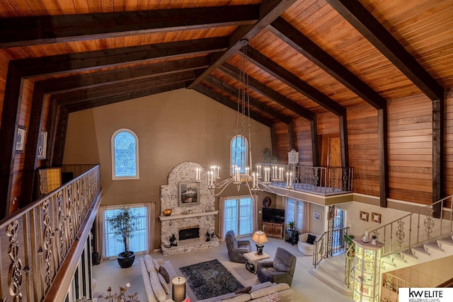 unfurnished living room with a fireplace, beam ceiling, an inviting chandelier, high vaulted ceiling, and wooden ceiling