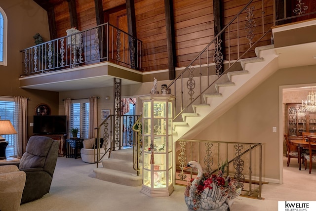 stairway featuring carpet flooring, a towering ceiling, and a chandelier