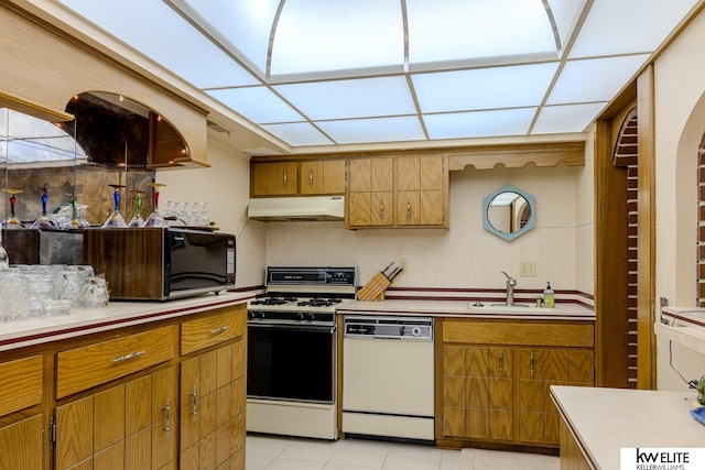 kitchen with light tile patterned floors, sink, and white appliances