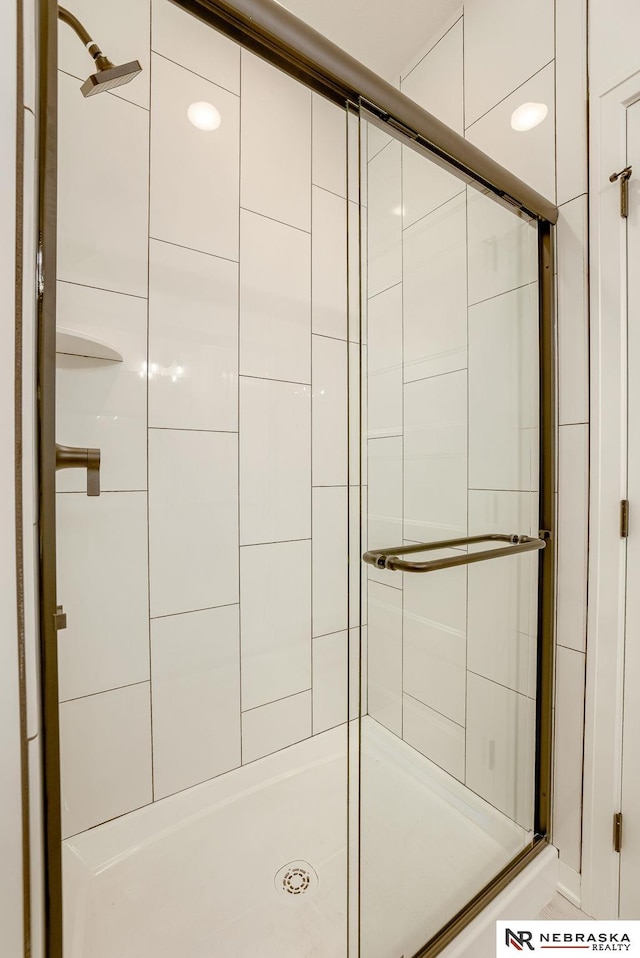 bathroom with a shower with door