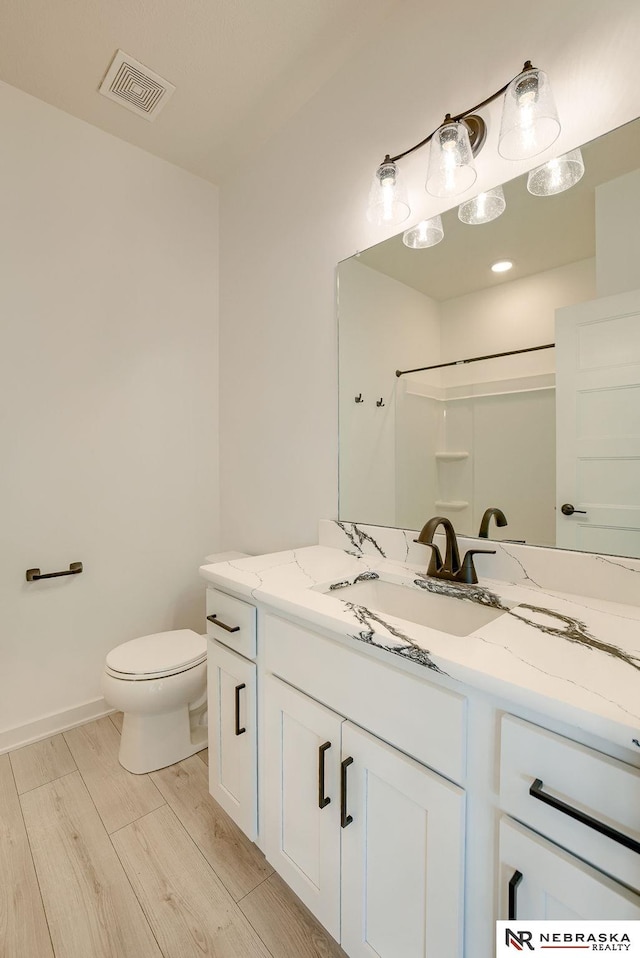 bathroom featuring vanity, toilet, and walk in shower