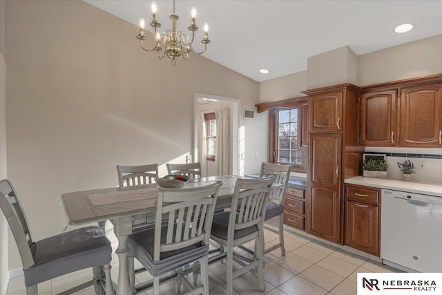 dining area featuring light tile patterned flooring, vaulted ceiling, and an inviting chandelier