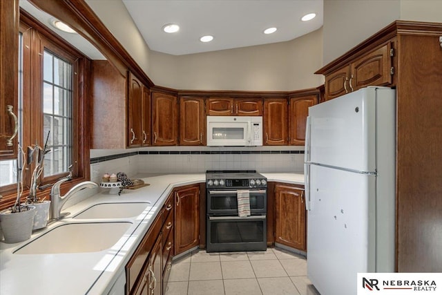 kitchen featuring sink, white appliances, light tile patterned floors, and tasteful backsplash