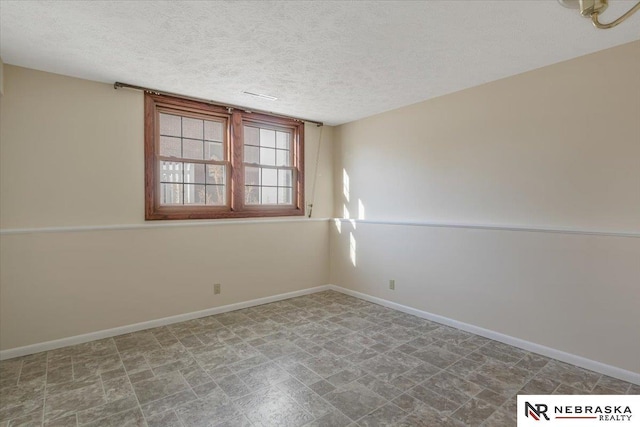 unfurnished room with a textured ceiling