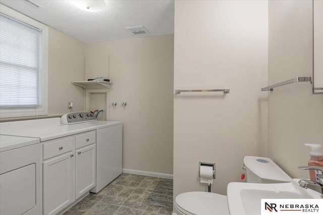 bathroom featuring toilet, washing machine and dryer, sink, and a textured ceiling